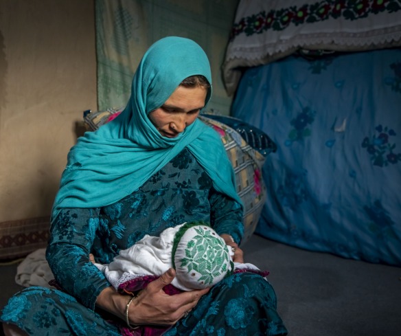 Nadia nurses her youngest child, 2 months old, at home in Duykondi Province, Afghanistan. Action Against Hunger works in this area to manage feeding programs and provide mobile health and nutrition support.