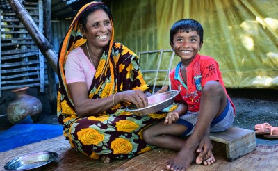 A grandmother feeds her grandson at home.