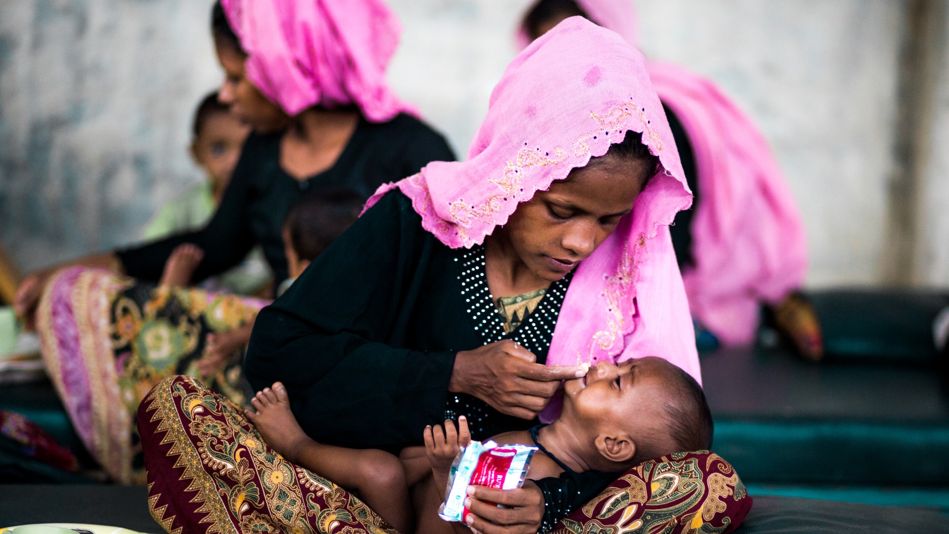 A mother gives her baby Plumpy'Nut to treat malnutrition at an Action Against Hunger nutrition center.