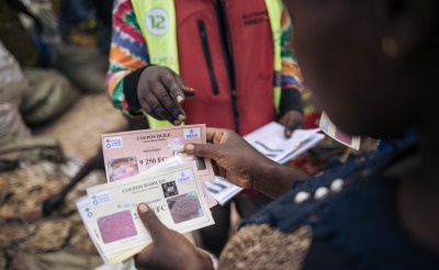 A woman holds her food vouchers up.