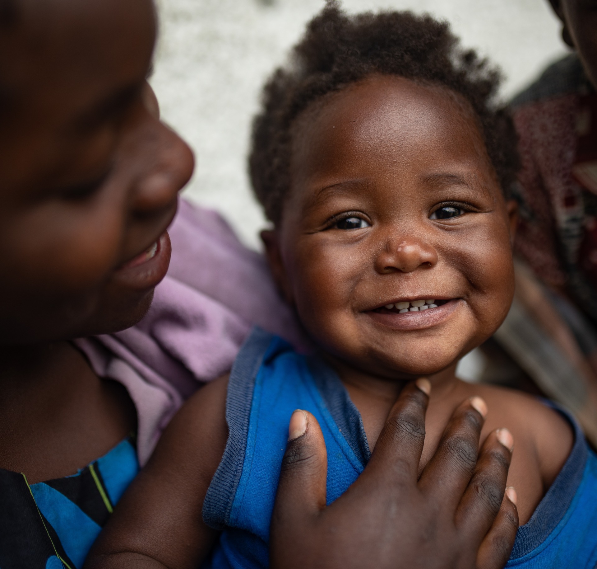 A girl holds her smiling little sister.