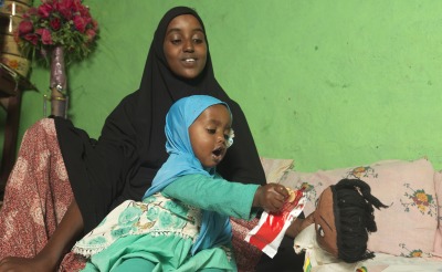 Medina's daughter Munira, attempts to playfully feed Plumpy'Nut to her doll inside their home in Guchi, Ethiopia.