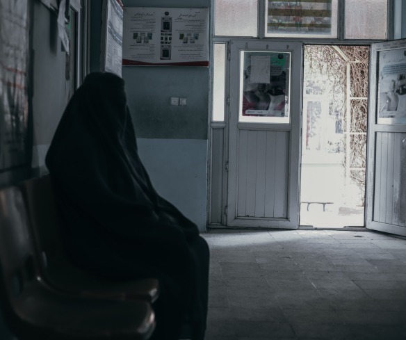 A woman waits for care in a health center in Afghanistan.