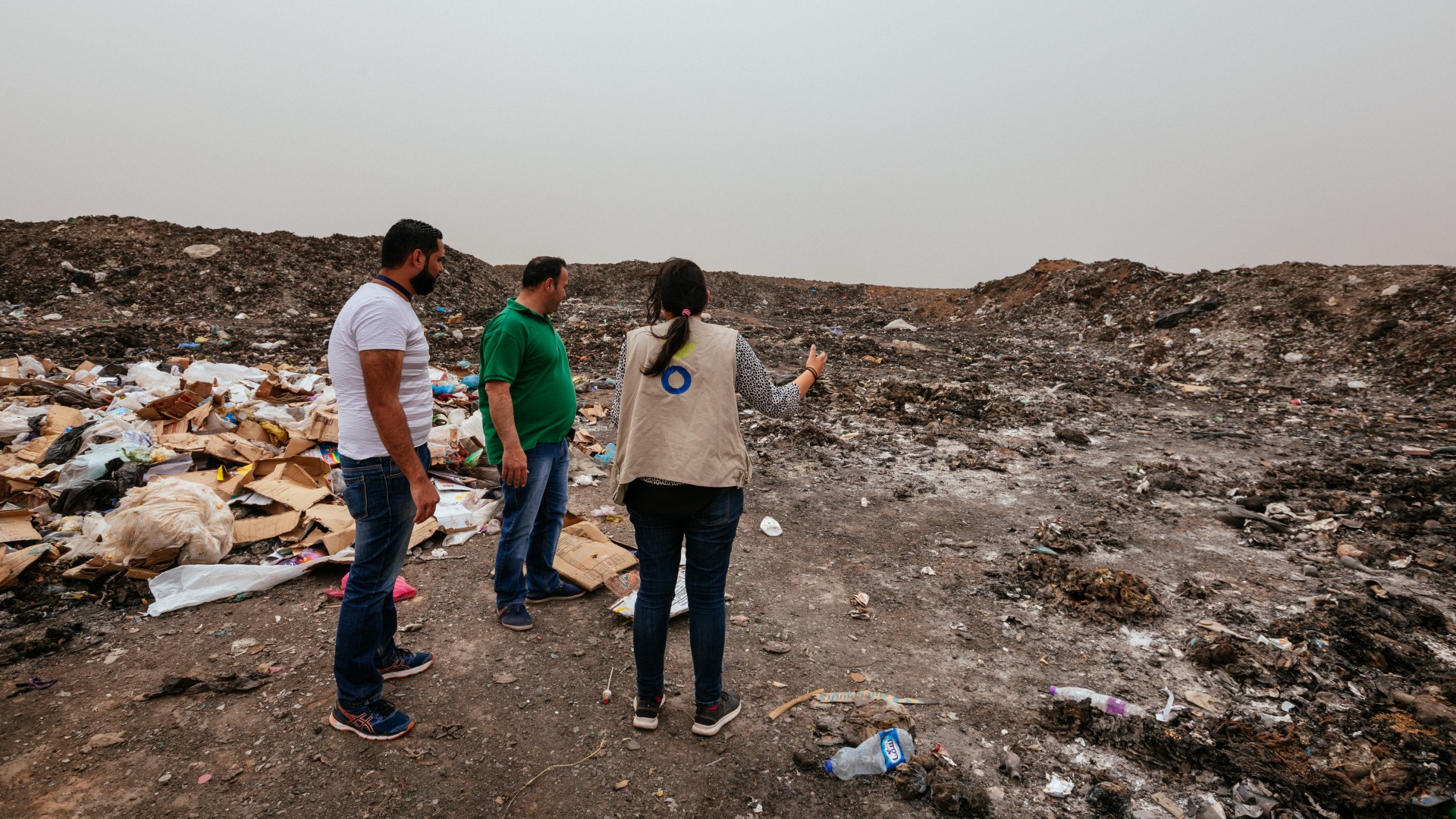 An Action Against Hunger staff member stands in front of an open dump near Azaraq Town.