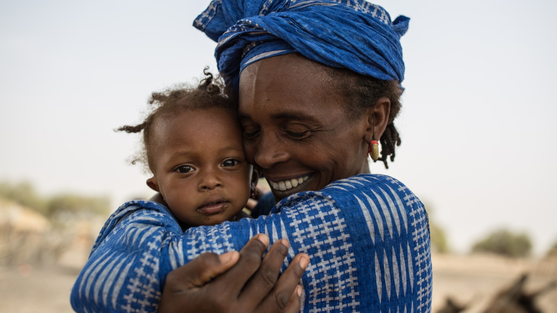 A woman hugs her daughter