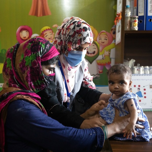 Dr. Zarina Lashari, a nutrition assistant, consults with a mother and child at an outpatient treatment center in Sindh, Pakistan.