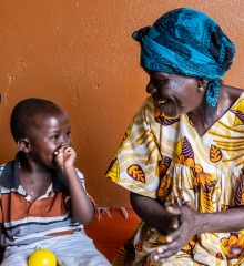A child disabled by severe malnutrition at a young age is receiving motor skills training at the Rehabilitation center for the physically disabled (CRHAM) supported by ACF. Here, he is surrounded by the mother of another child like him and by his grandmother. Bangui, CAR. 2022