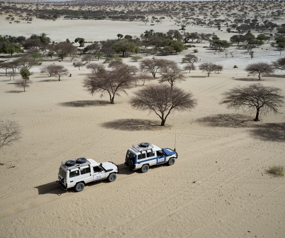Action Against Hunger trucks drive through a desert in the Sahel region of West Africa.